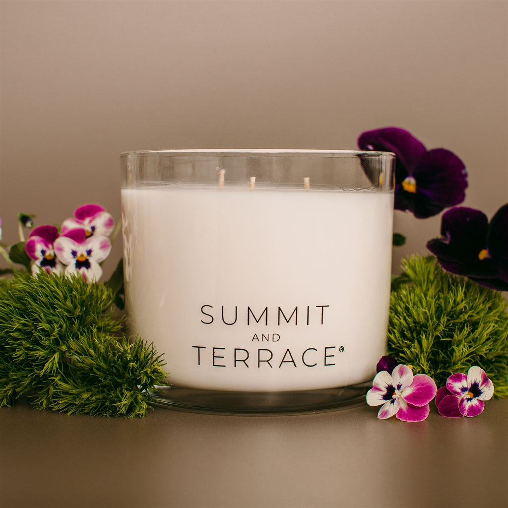Fiori Muse Grande Candle with three wicks in a glass vessel—featuring geranium, rose, and patchouli for open spaces and thoughtful housewarming gifts.